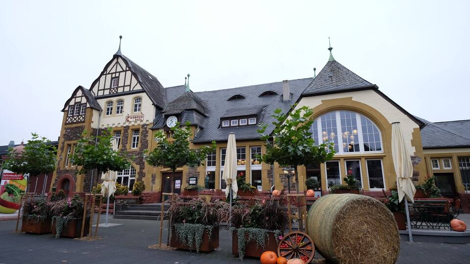 A traditional building with a clock tower, large windows, and a sign that reads "PUSANUS."