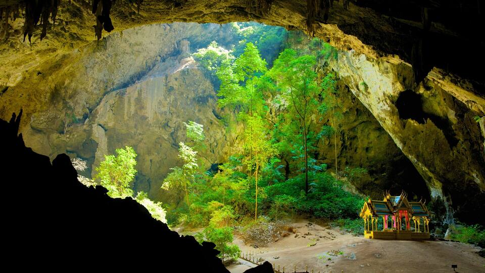 A cave with a view of a forest and a temple.