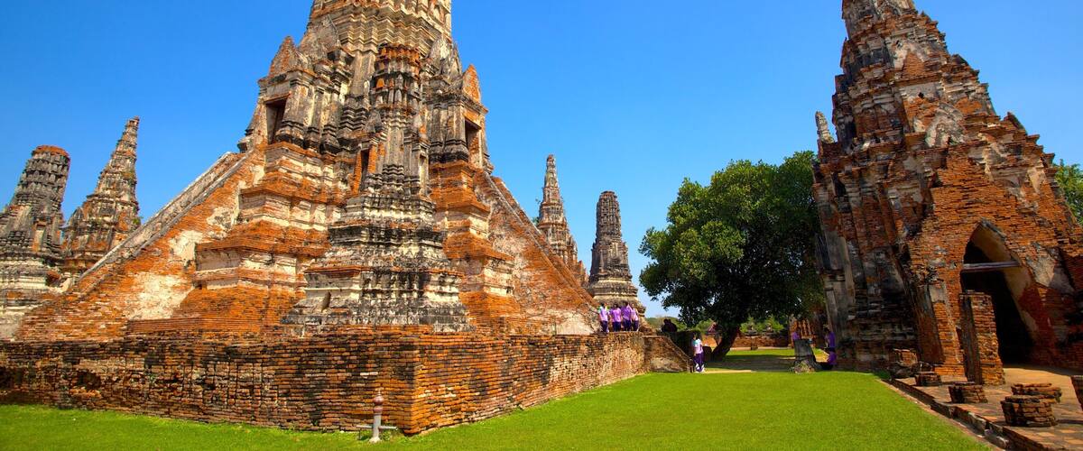 An ancient temple complex with multiple tiered structures and a well-maintained lawn.