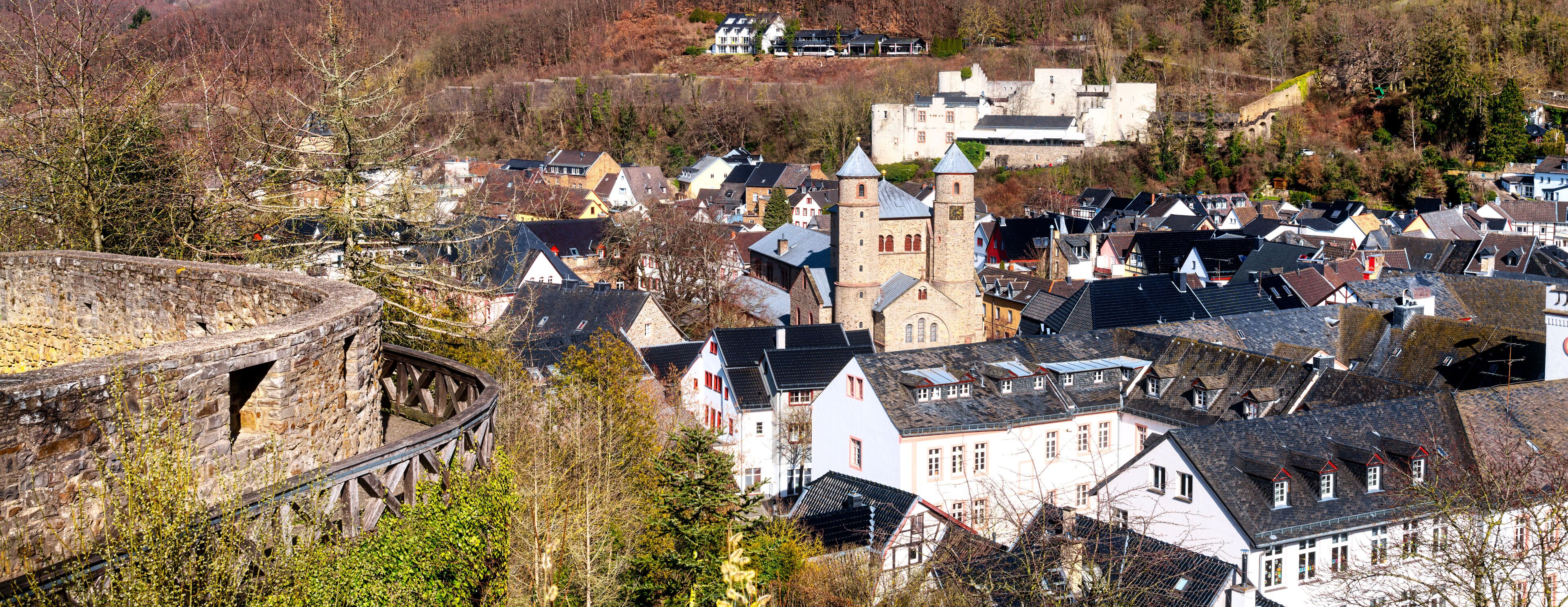 A historic town with a prominent tower, cobblestone streets, and a stone bridge.