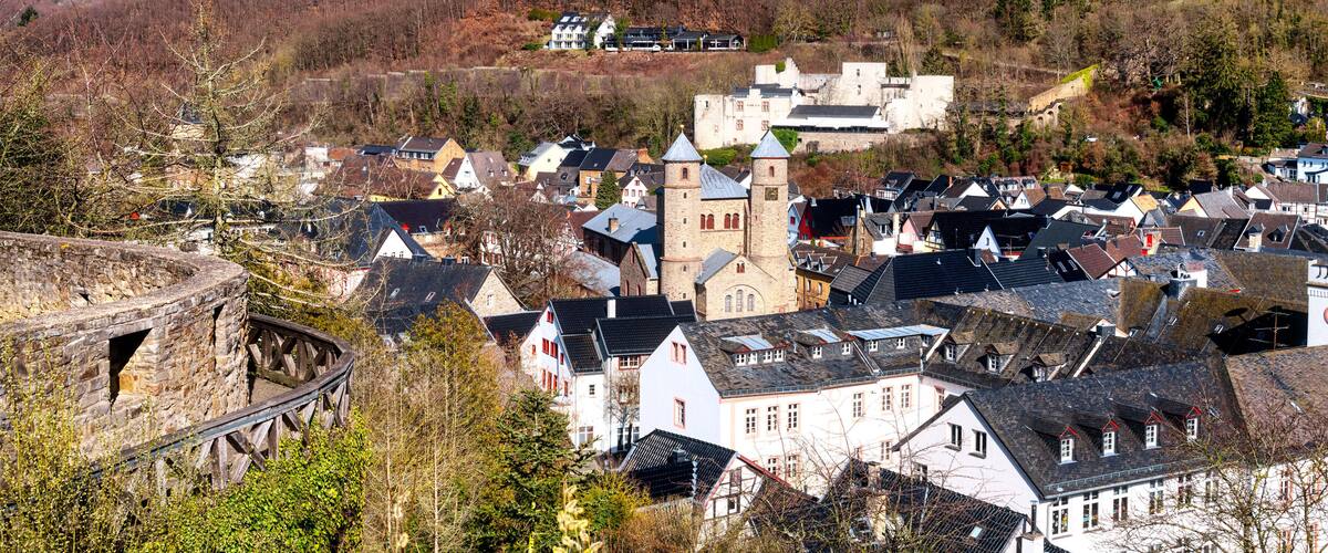A historic town with a prominent tower, cobblestone streets, and a stone bridge.