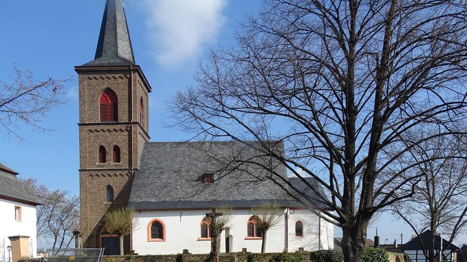 A church with a tall steeple and a white building with red windows.