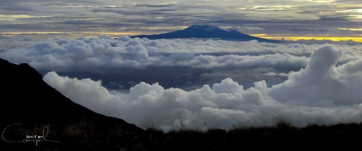 A mountain with clouds below.