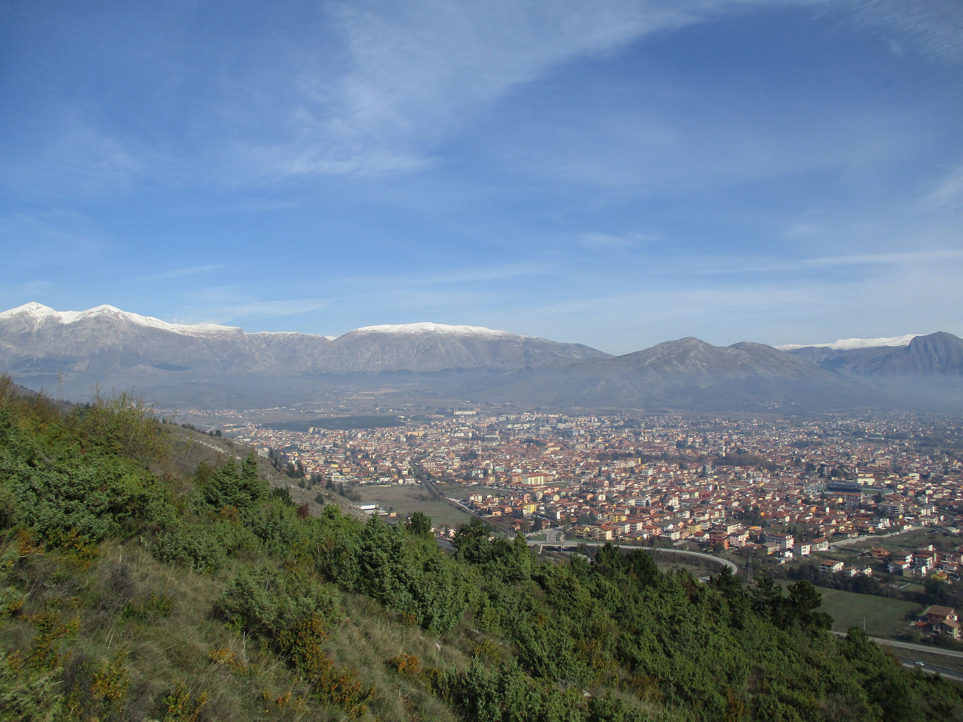 A cityscape with snow-capped mountains in the background.