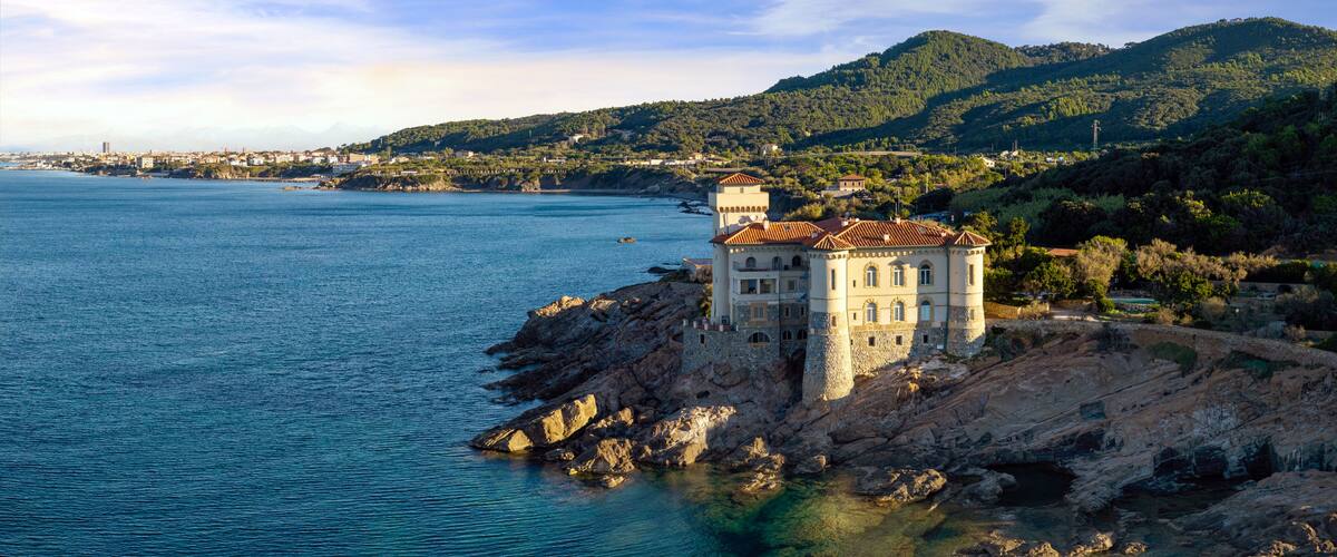 A coastal town with a prominent castle-like building on a rocky outcrop.