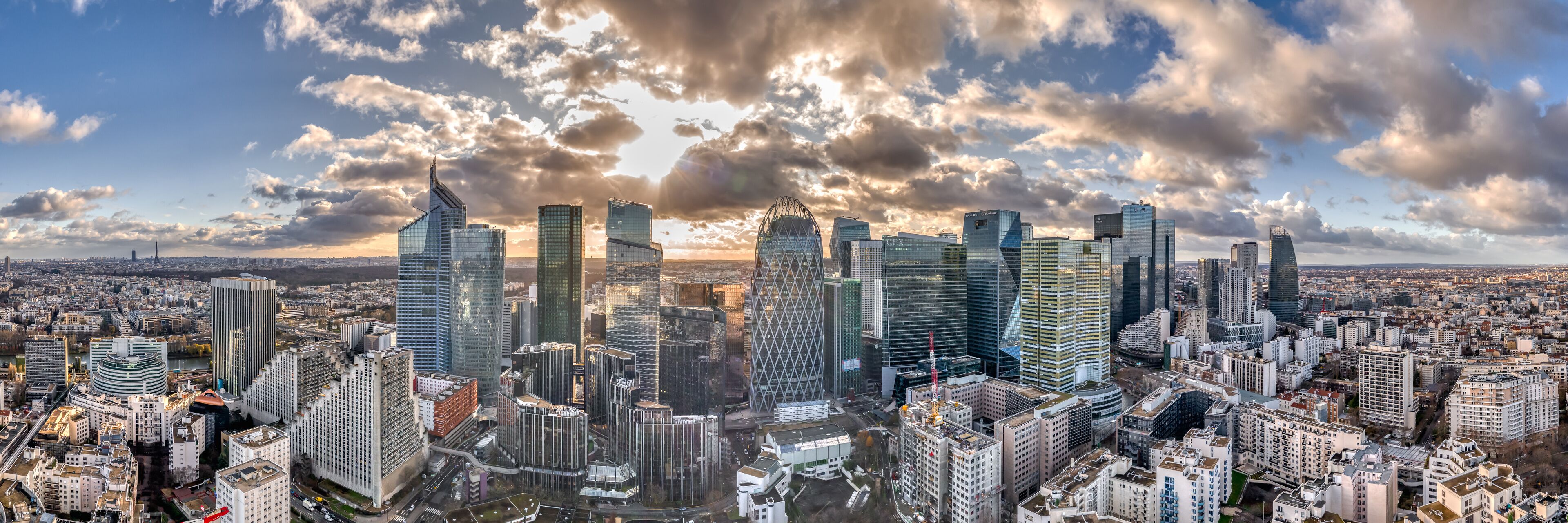 A cityscape with modern skyscrapers and a cloudy sky.
