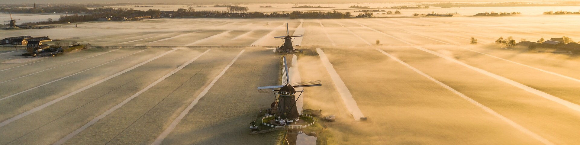 Vue aérienne d’un moulin à vent situé dans un champ, à proximité de terres agricoles.