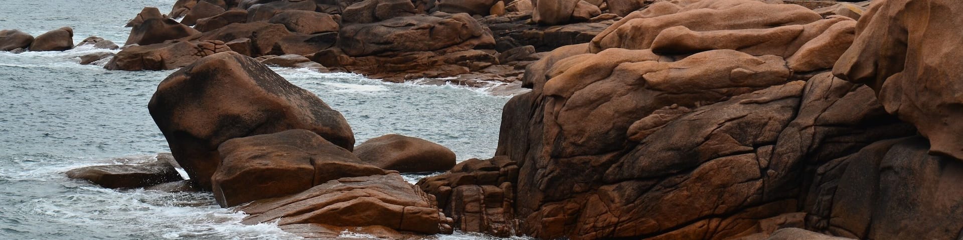 The lightouse sitting on the pink granite rock formation in Perros-Guirec in Brittany Northern France.