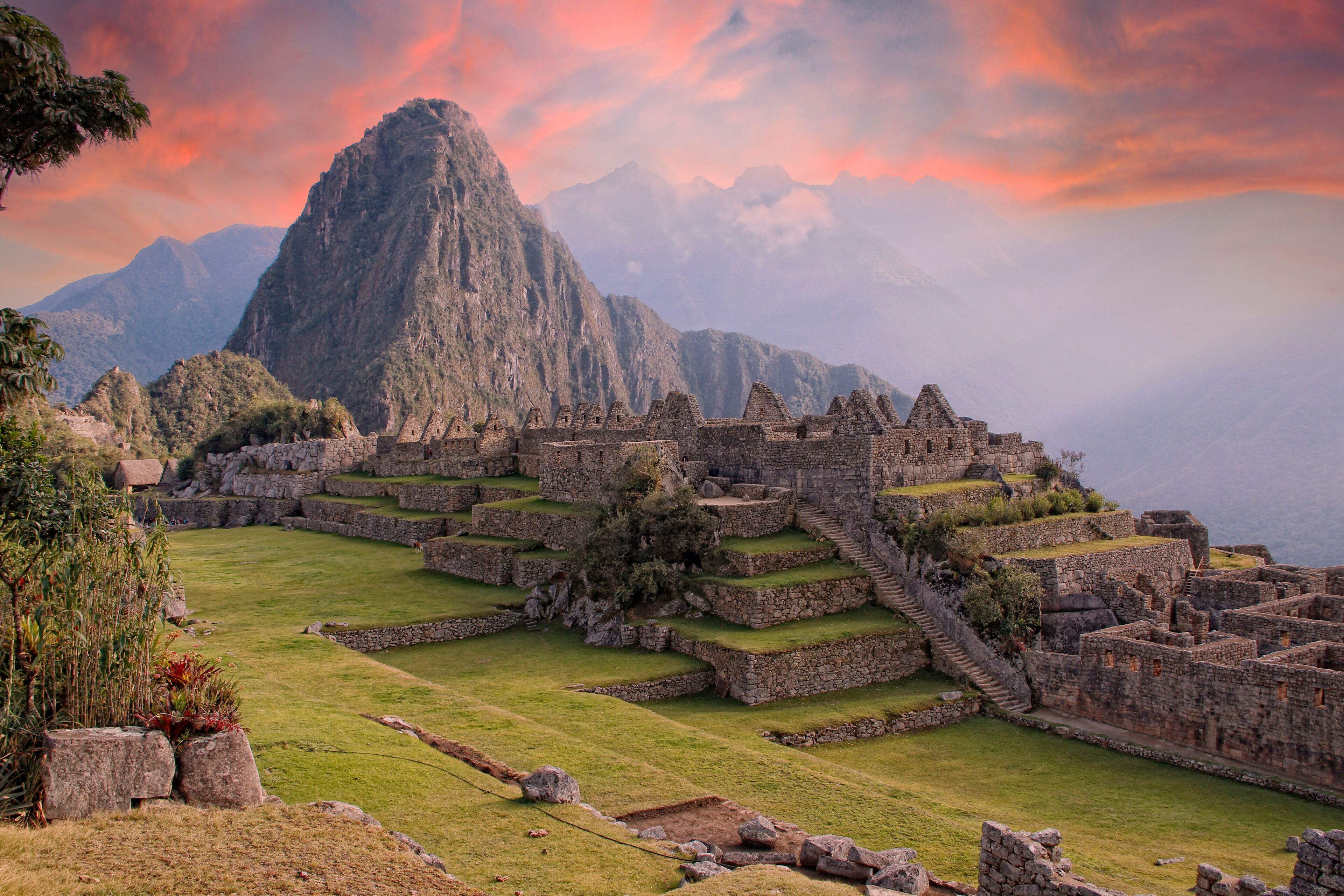 Ruinas de Machu Picchu con campos en terrazas y una montaña al fondo.