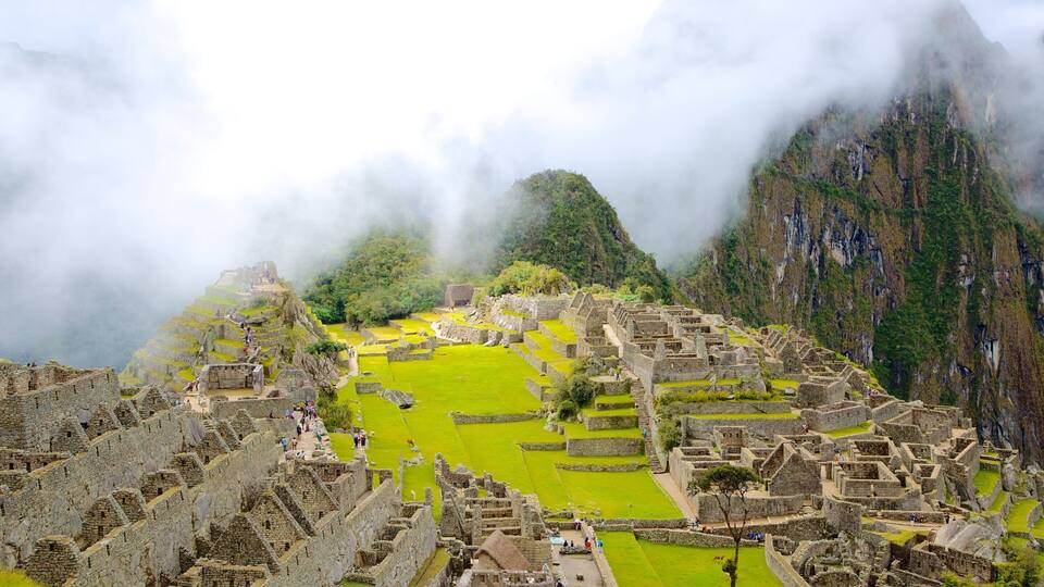 The ancient Incan ruins of Machu Picchu with terraced fields and steep mountain backdrop.