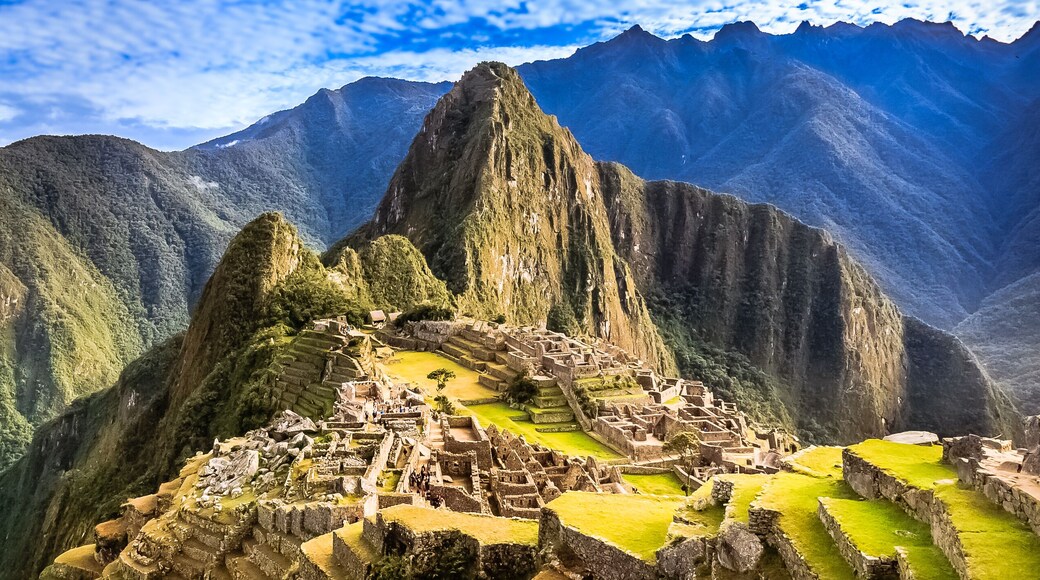Machu Picchu, una antigua ciudad inca, asentada en un valle montañoso con campos en terrazas y acantilados escarpados.