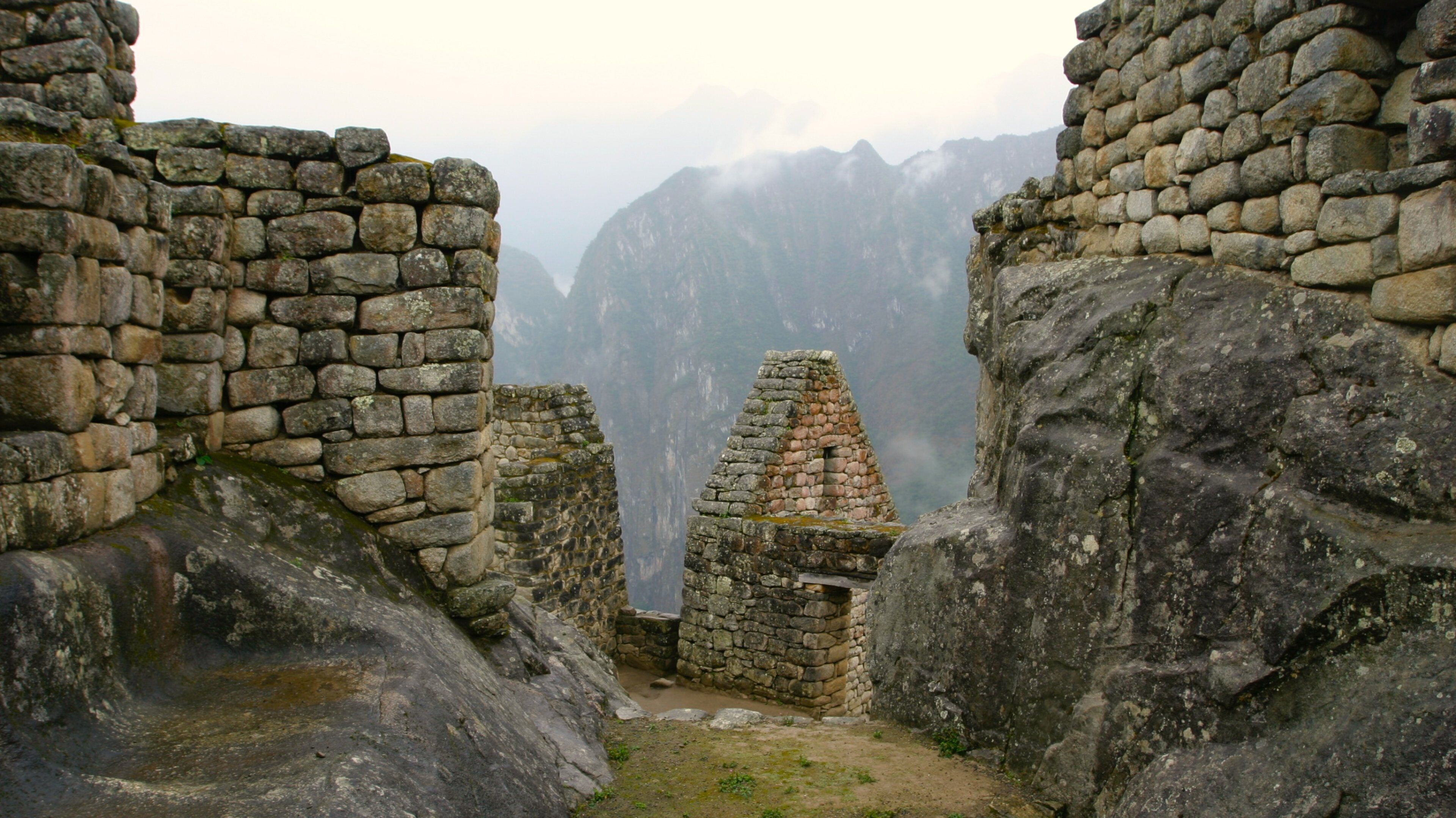 Machu Picchu which includes building ruins and mist or fog