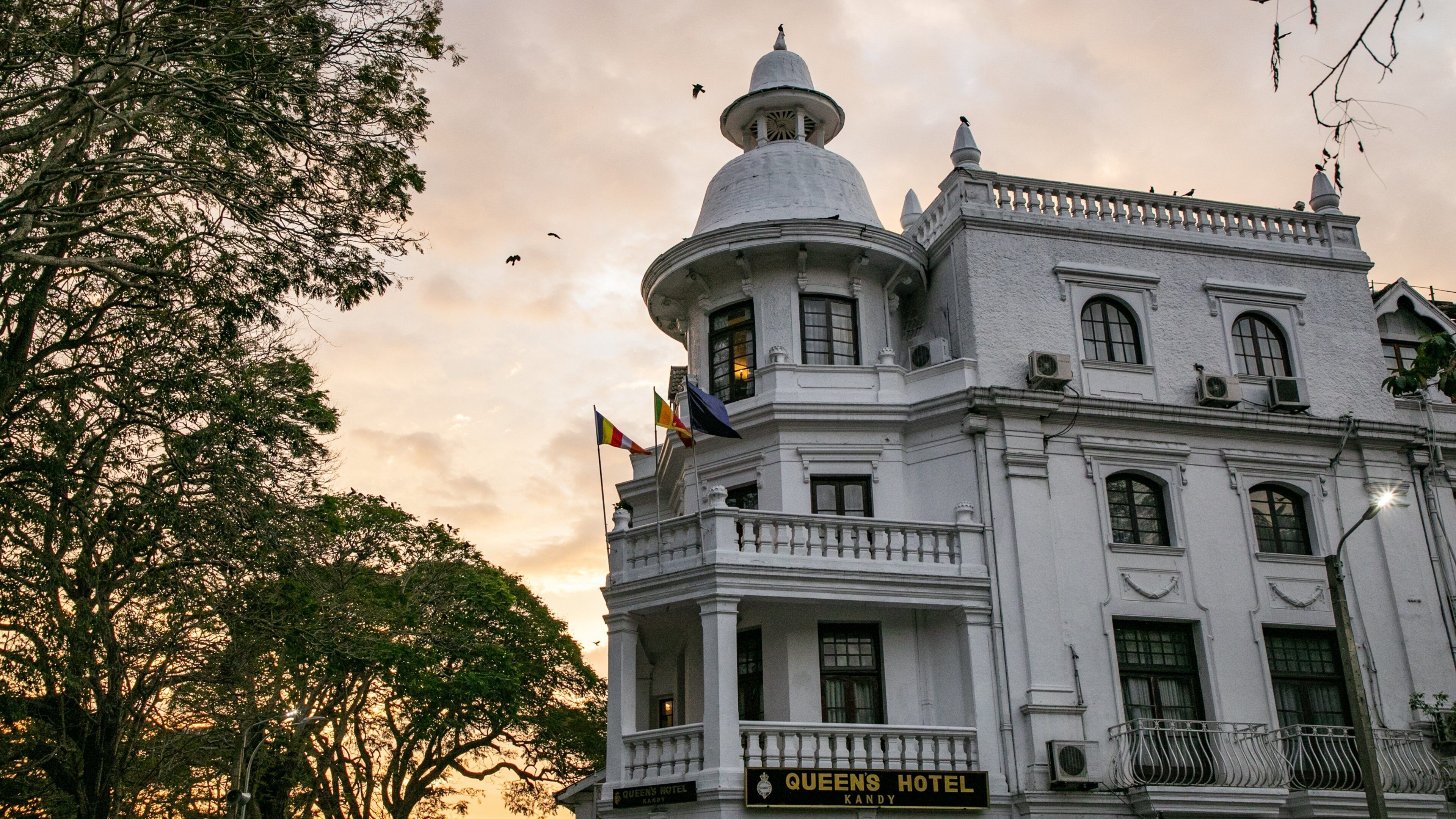 A historic building with a prominent dome and multiple flags.
