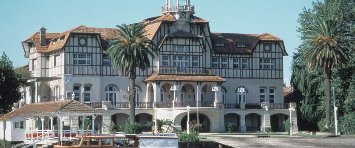 A large, historic building with a prominent tower and multiple arches.