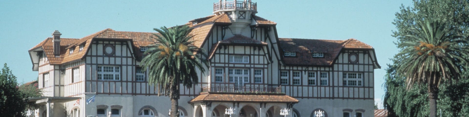 A large, historic building with a prominent tower and multiple arches.