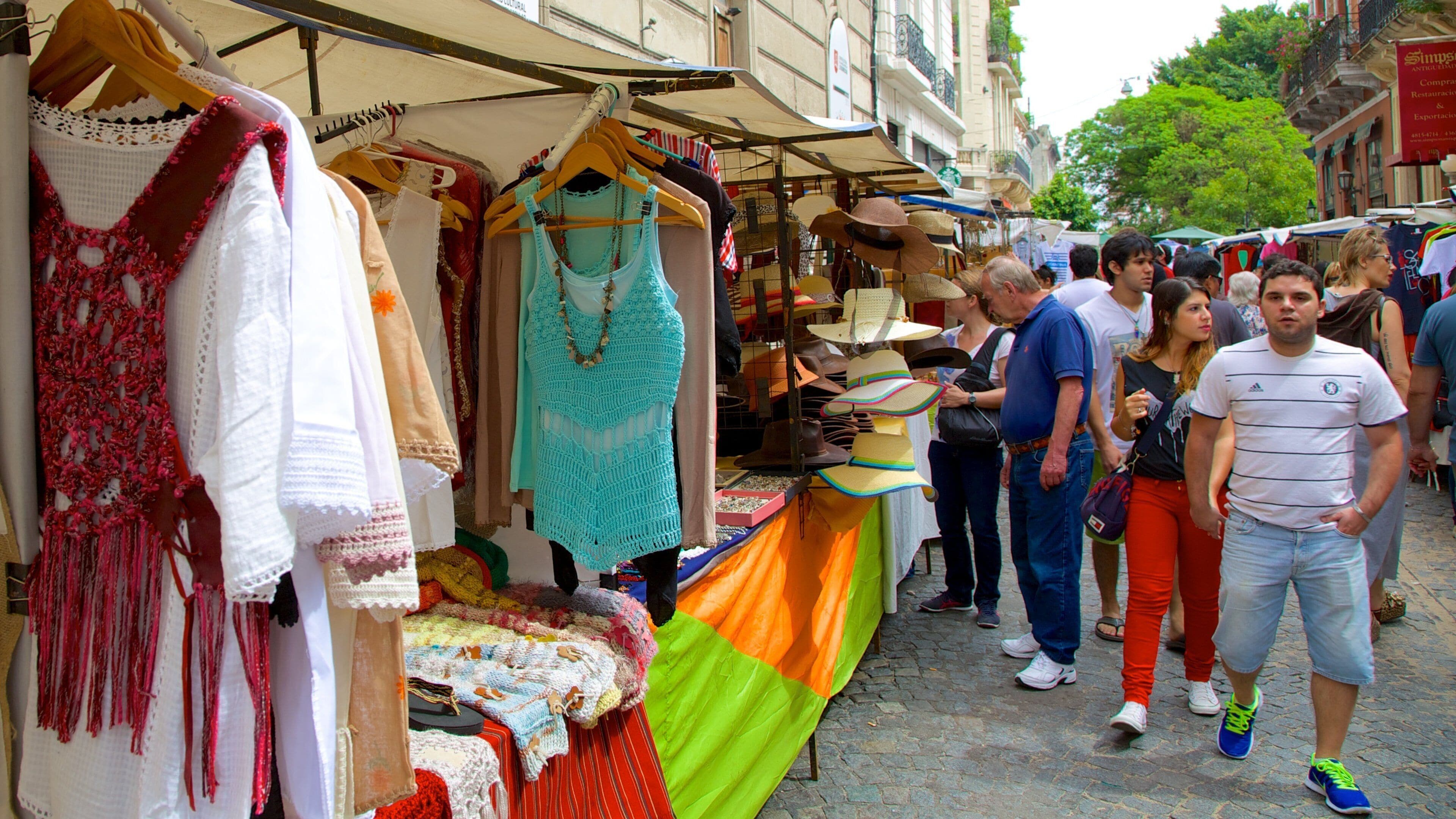 A street market with various stalls selling handmade crafts and accessories.