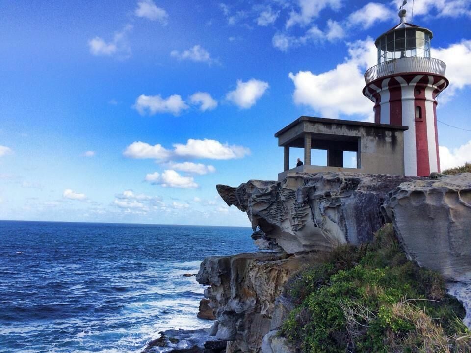 A lighthouse on a rocky cliff overlooking the ocean.