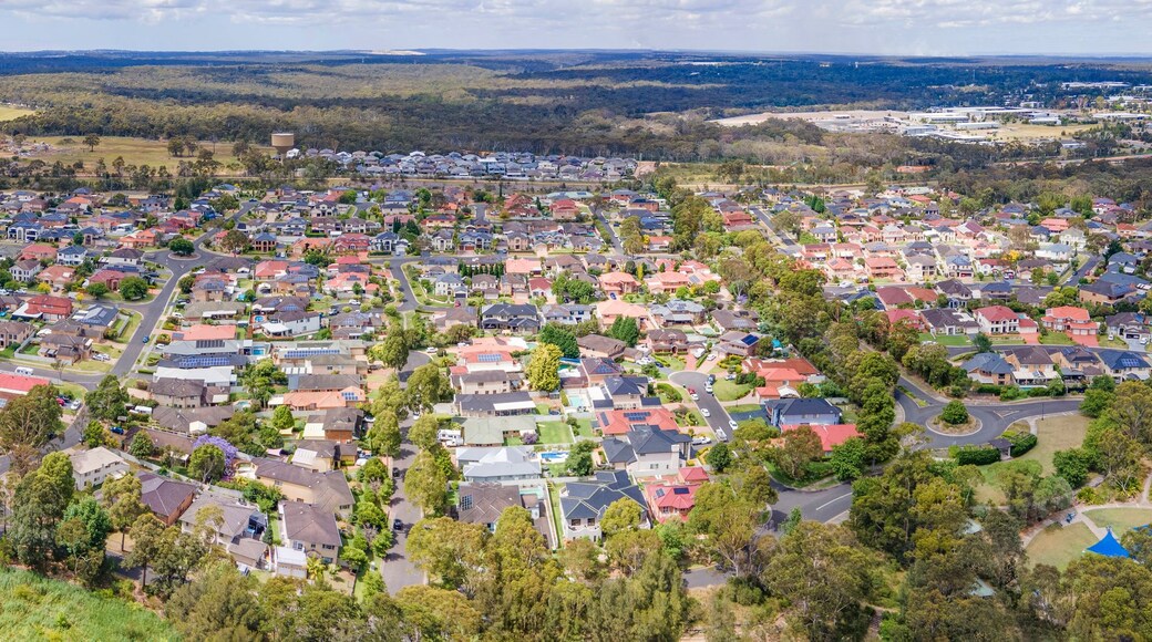 Vue aérienne d’un quartier résidentiel avec des maisons, des routes et une rivière.