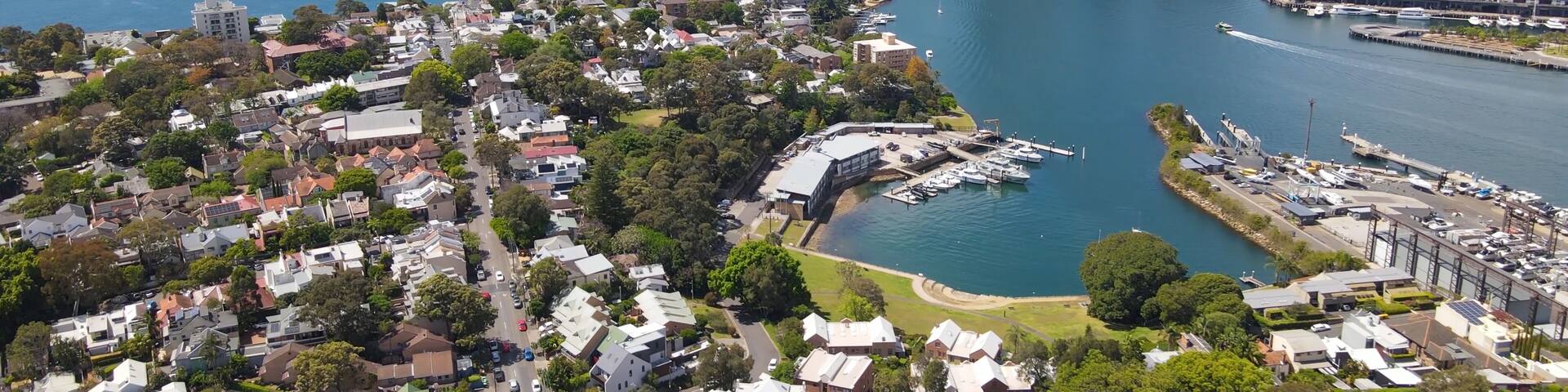 Aerial drone view over Balmain in Sydney, New South Wales, Australia looking toward Balmain East showing Sydney Harbour Bridge and Sydney City in the background on a sunny day