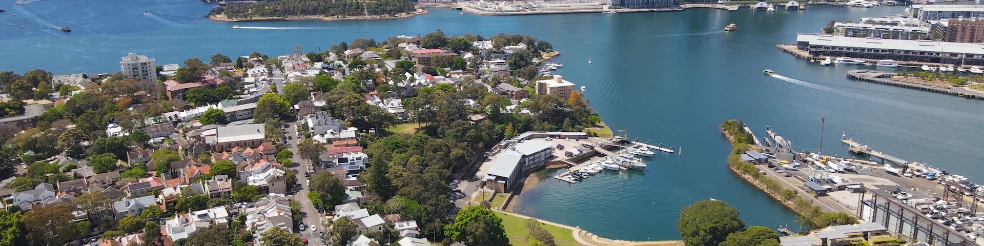 Aerial drone view over Balmain in Sydney, New South Wales, Australia looking toward Balmain East showing Sydney Harbour Bridge and Sydney City in the background on a sunny day
