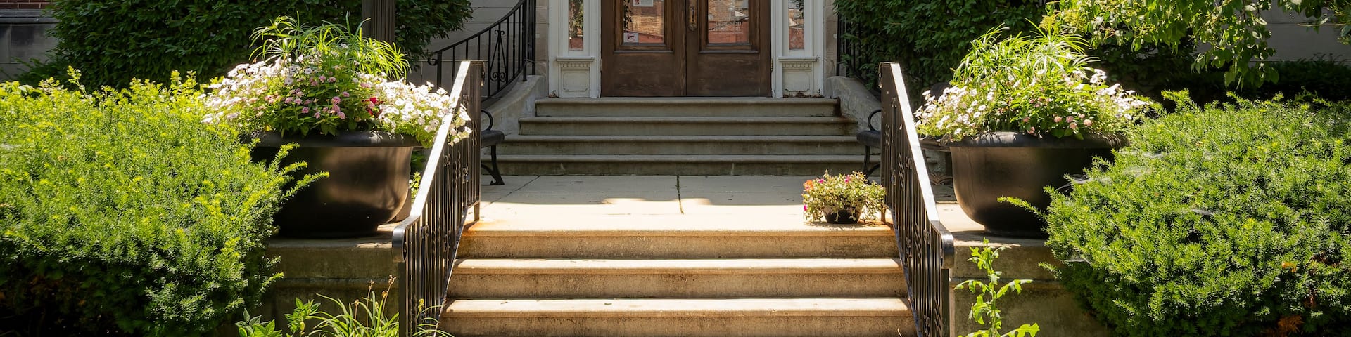 A brick building with a sign reading 'LA GRANGE VILLAGE HALL' and a set of stone steps leading to the entrance.