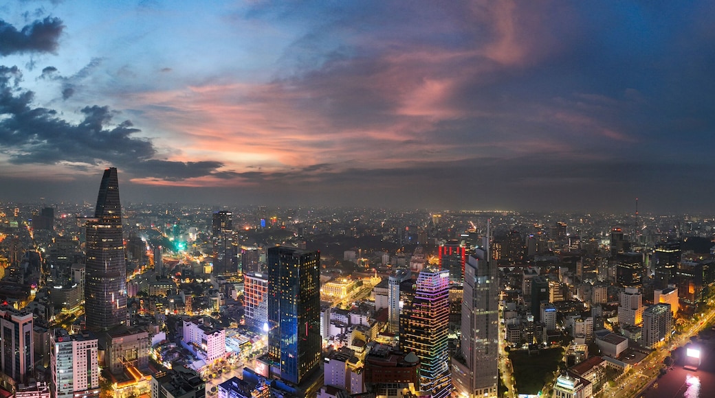 Vast panoramic night view of Ho Chi Minh City skyline at sunset with illuminated skyscrapers and the Saigon River