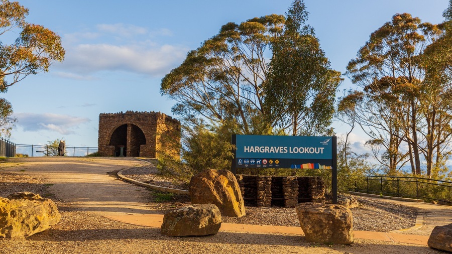 Señal para Hargreaves Lookout, con un edificio de piedra al fondo.