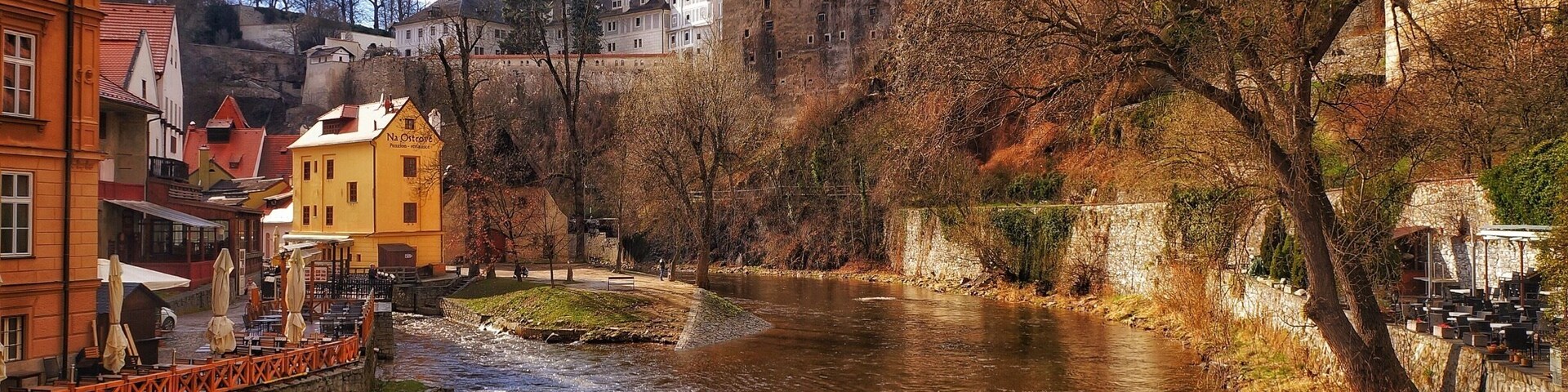 Un río serpentea por un pueblo con edificios históricos y un puente.