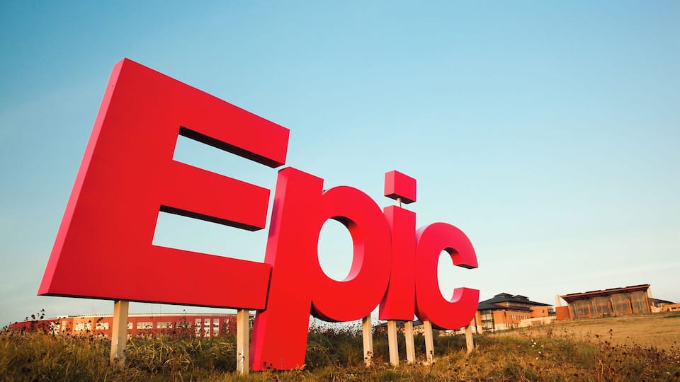 A large red sign with the word "Epic" in a modern font, set against a clear blue sky.