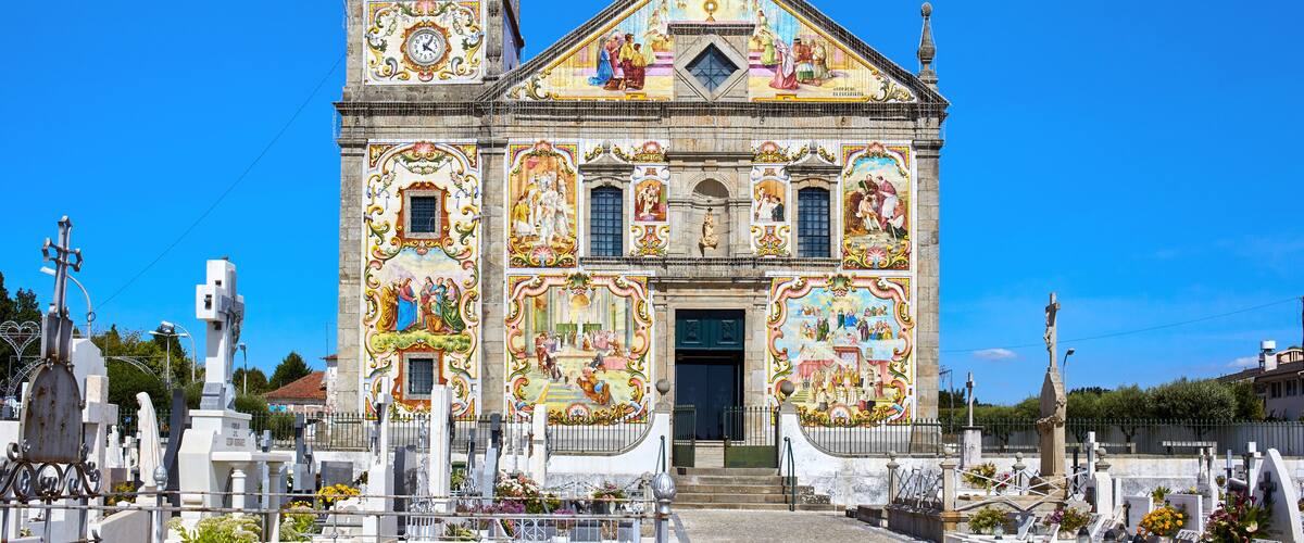 A church with a bell tower and colorful murals.