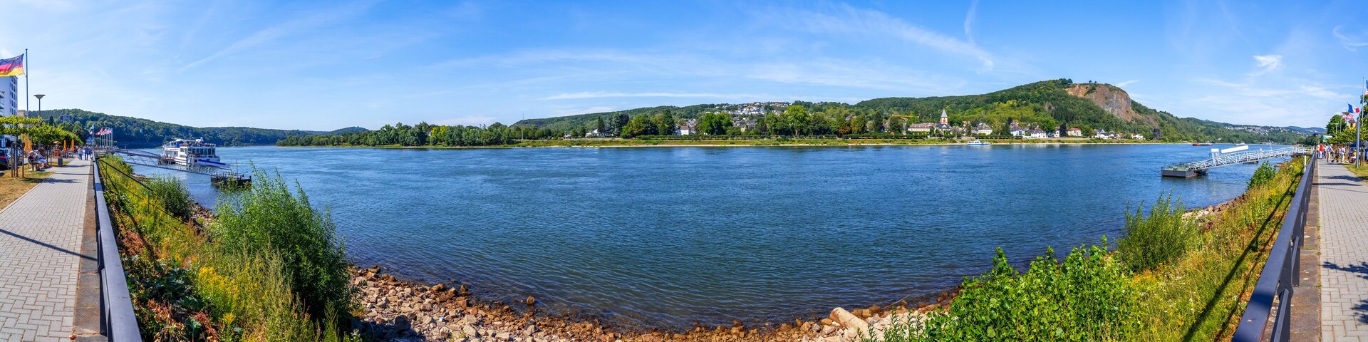A river with a bridge, a hill with a church, and a row of houses along the riverbank.
