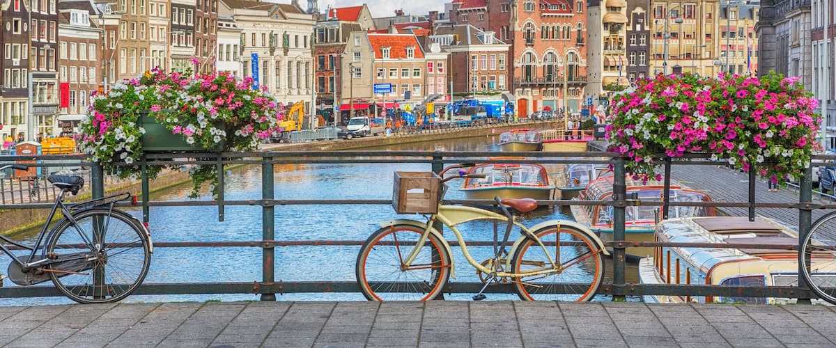A canal with boats, bicycles, and historic buildings.