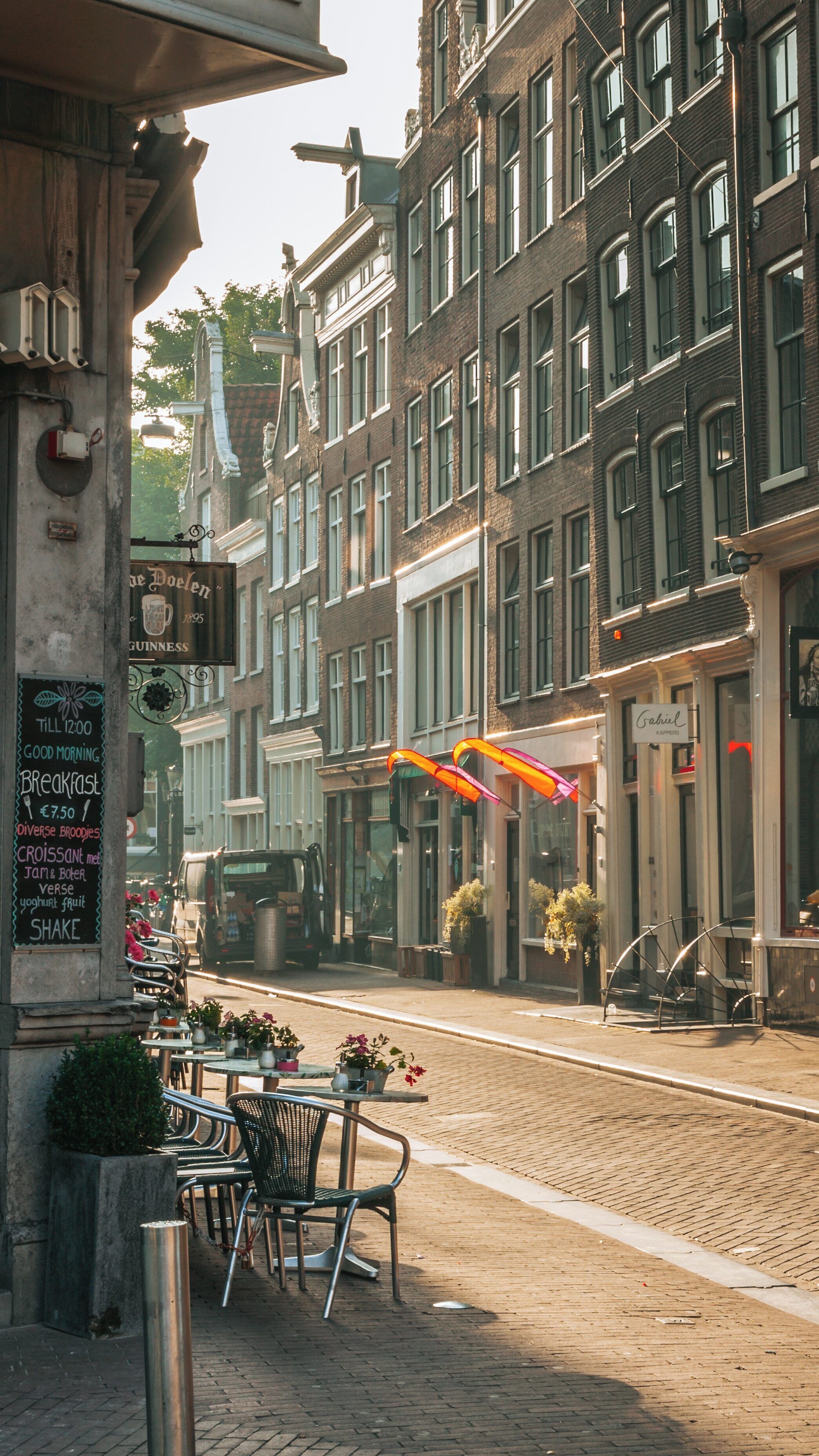Morning light illuminates Muntplein in the Canal Ring, Amsterdam revealing vibrant architecture and street cafes
