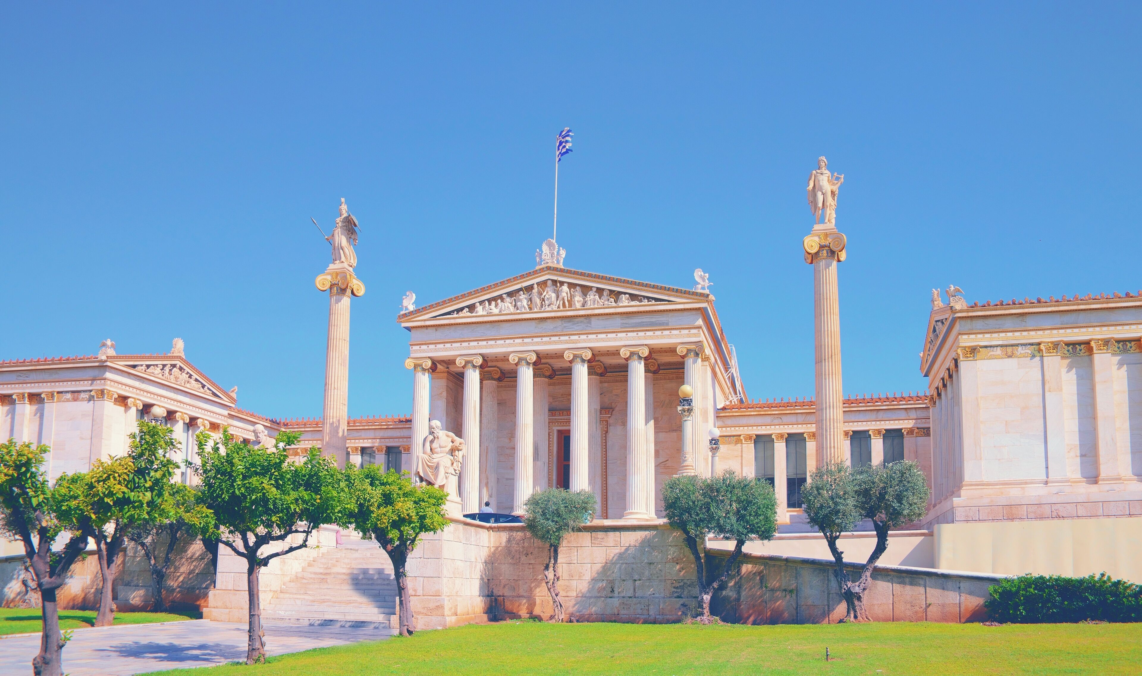 A classical Greek temple with columns and statues.