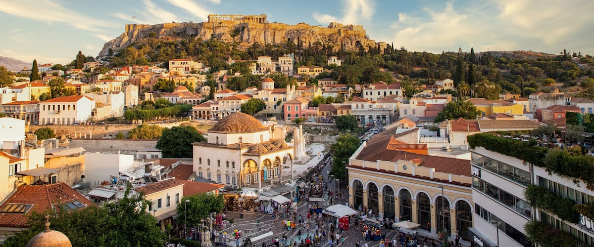 A historic town with a prominent castle on a hill, surrounded by residential buildings and a bustling market square.