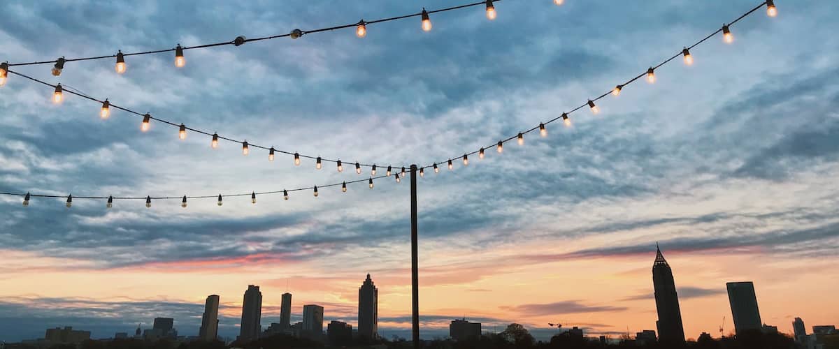A city skyline at dusk with string lights.