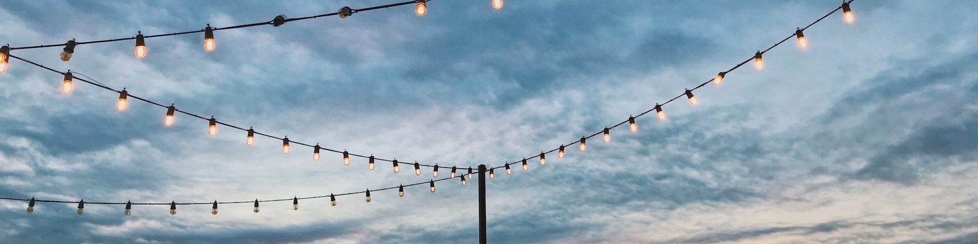 A city skyline at dusk with string lights.