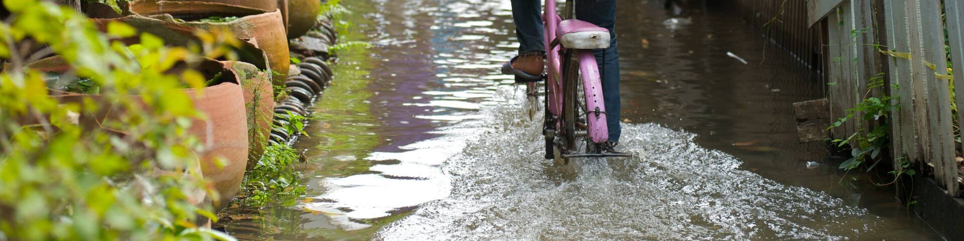 Cycling through flooded streets in Bangkok's vibrant neighborhoods during rainy season