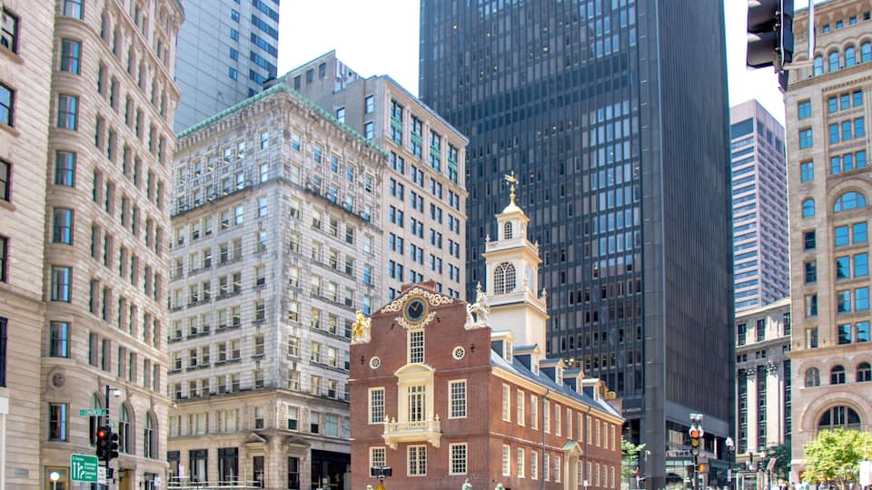 A historic building with a clock tower in a cityscape.
