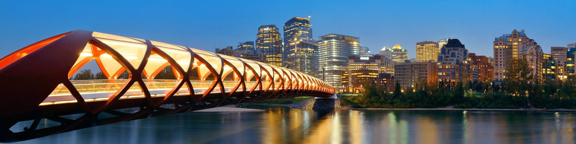 Calgary cityscape with Peace Bridge and downtown skyscrapers in Alberta at night, Canada.