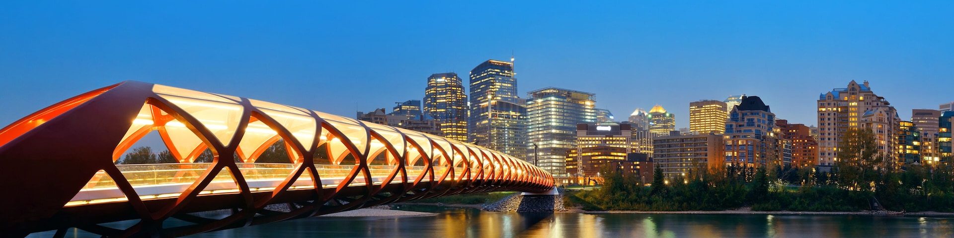 Calgary cityscape with Peace Bridge and downtown skyscrapers in Alberta at night, Canada.