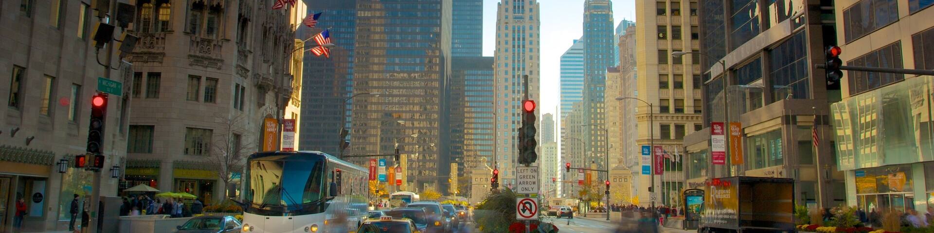 A busy city street with tall buildings, a bus, and cars.