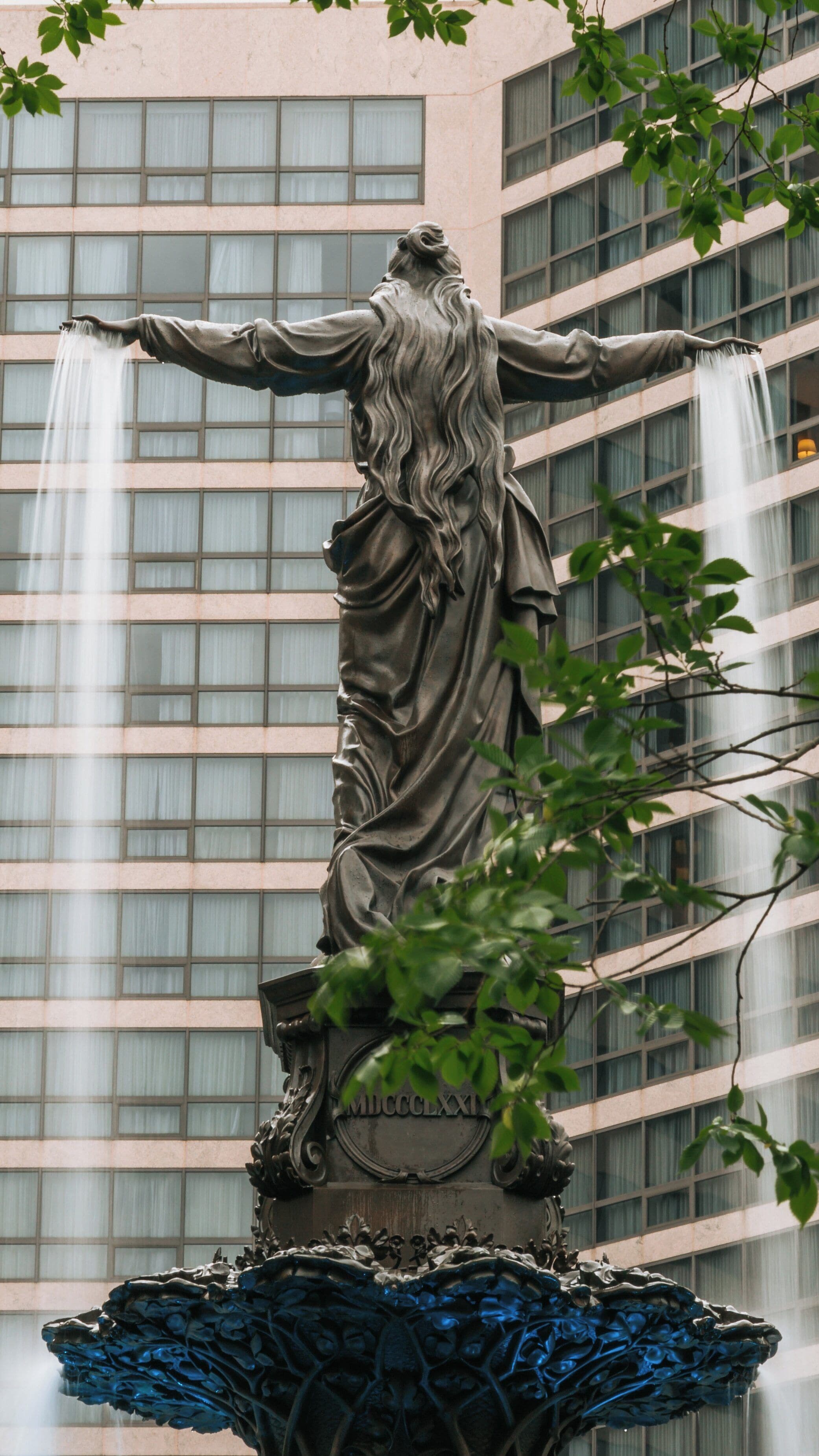 Fountain Square showcases its iconic statue with cascading water amidst downtown Cincinnati's skyscrapers