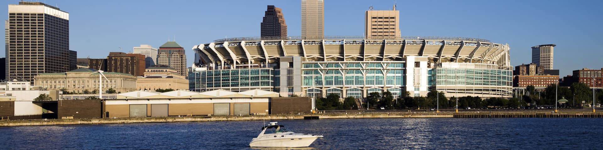 A waterfront cityscape with a prominent stadium and various modern buildings.