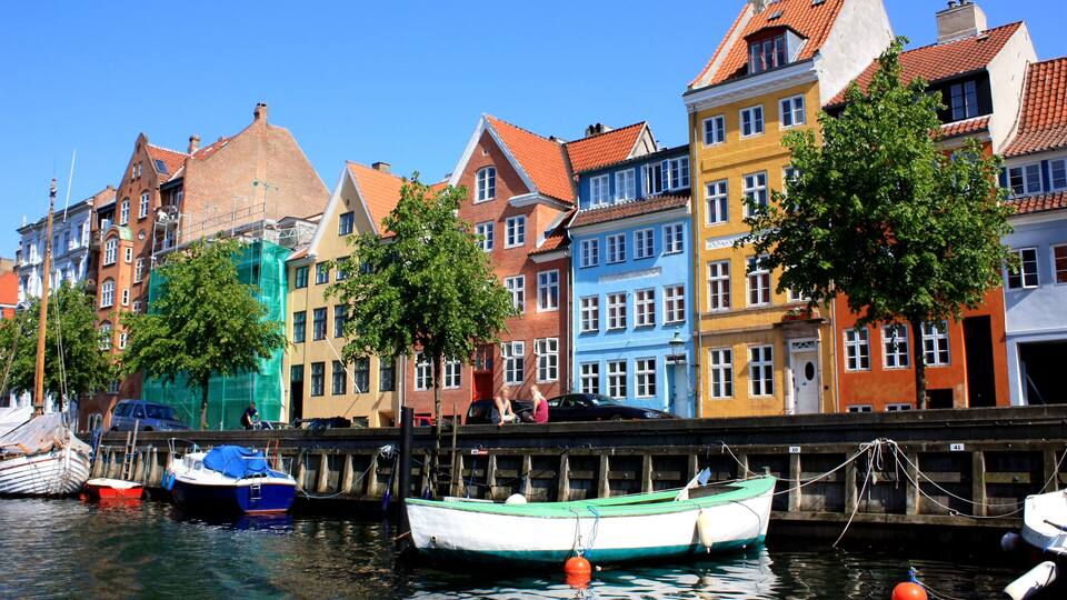 Colorful buildings along a canal with boats docked.