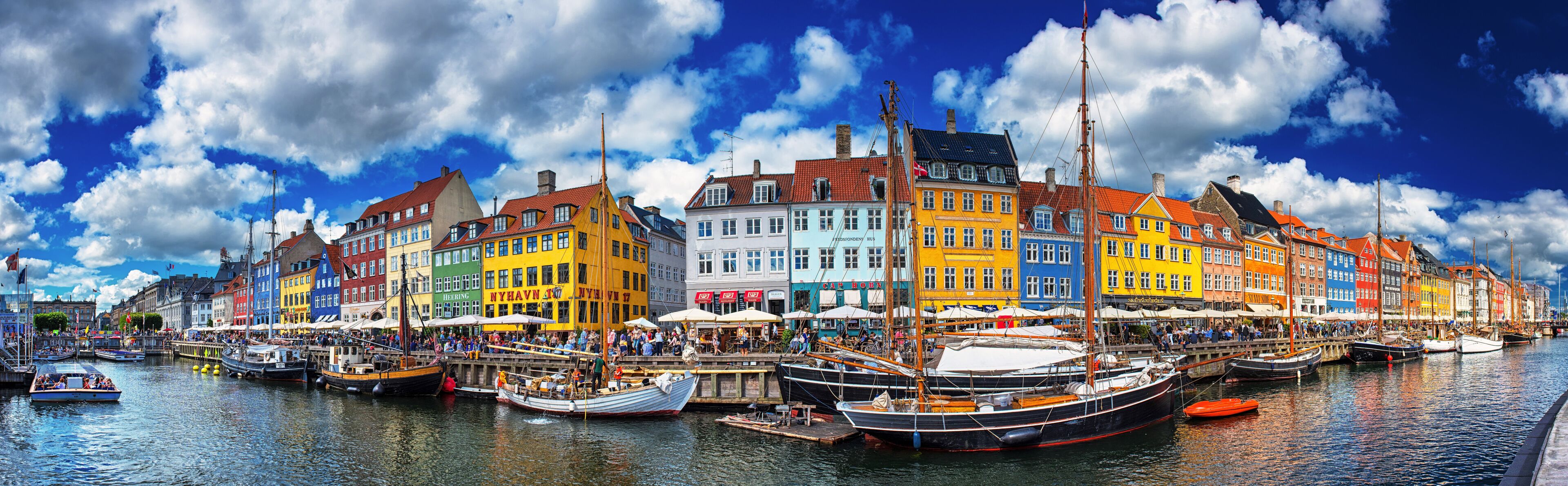 A colorful waterfront with traditional buildings and boats docked along the quay.