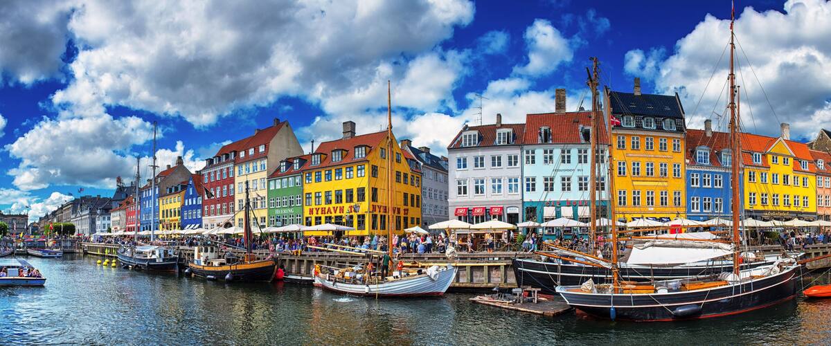 A colorful waterfront with traditional buildings and boats docked along the quay.