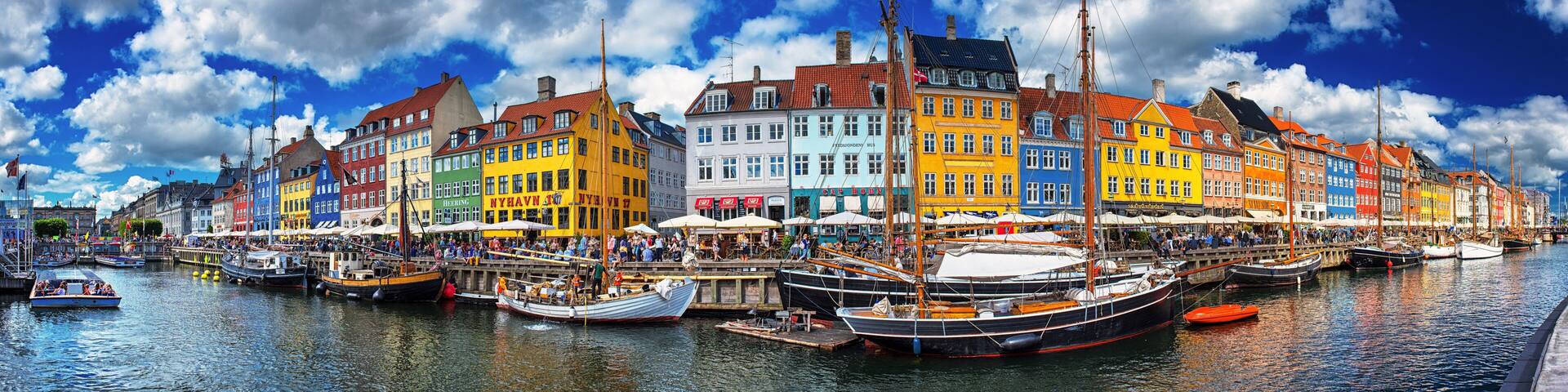 A colorful waterfront with traditional buildings and boats docked along the quay.