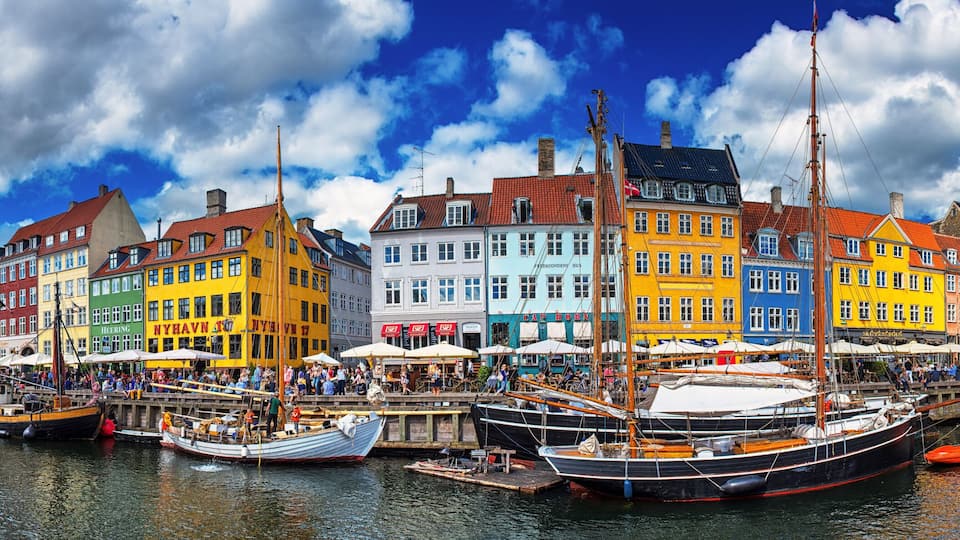 A colorful waterfront with traditional buildings and boats docked along the quay.