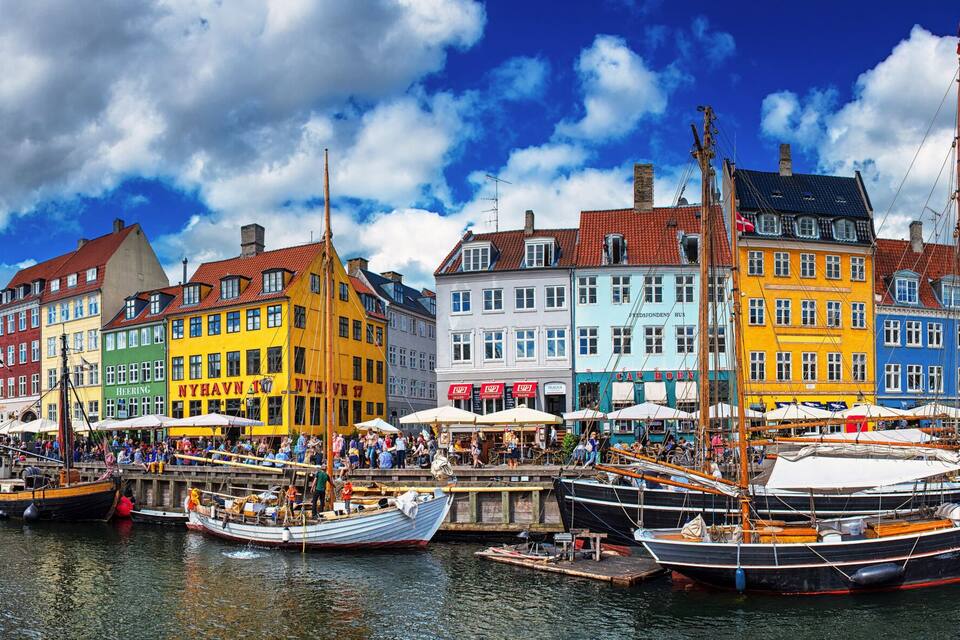 A colorful waterfront with traditional buildings and boats docked along the quay.